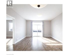 A spacious room with wooden flooring and a large window.