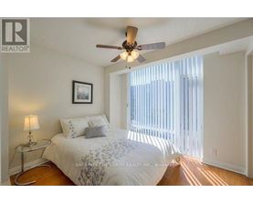 A bedroom with a bed, a ceiling fan, and a window with blinds.