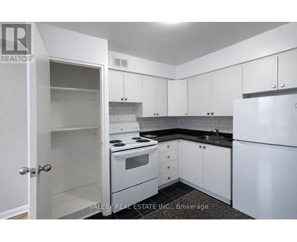 A kitchen with white appliances and cabinets.