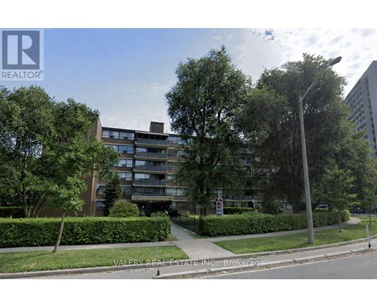 A street view of a residential area with apartment buildings and greenery.