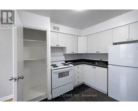 A kitchen with white appliances and cabinets.