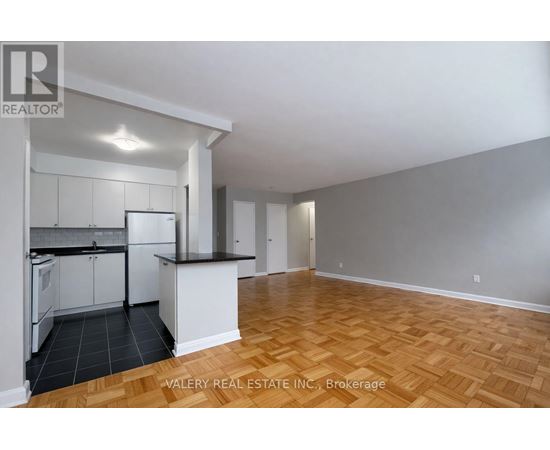 A kitchen with white cabinets and a black countertop is shown in the image.