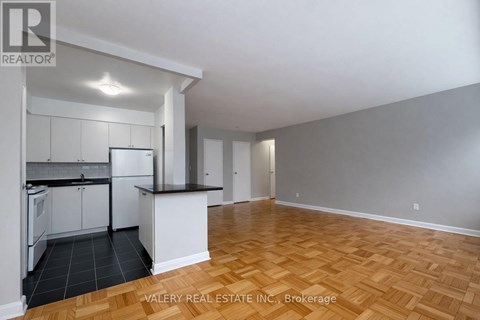 A kitchen with white cabinets and a black countertop is shown in the image.