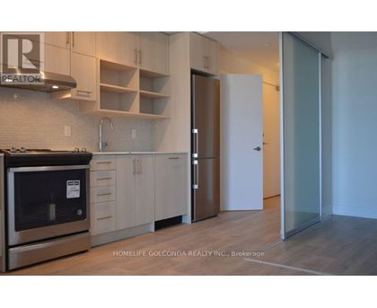 A modern kitchen with a stainless steel oven and white cabinets.