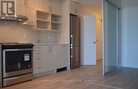 A modern kitchen with a stainless steel oven and white cabinets.