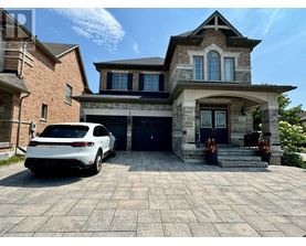 A white car is parked in front of a two-story house.