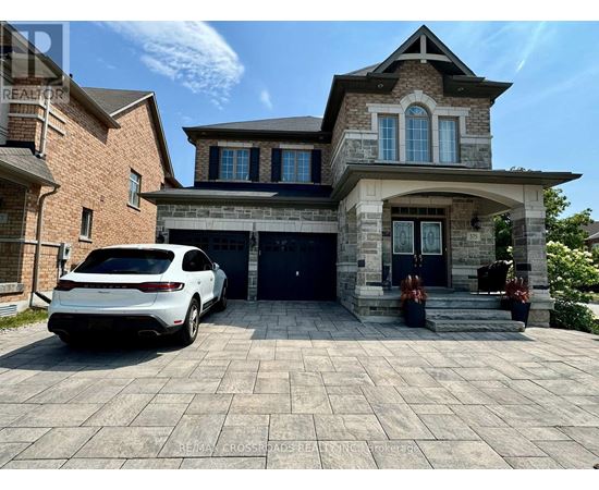 A white car is parked in front of a two-story house.