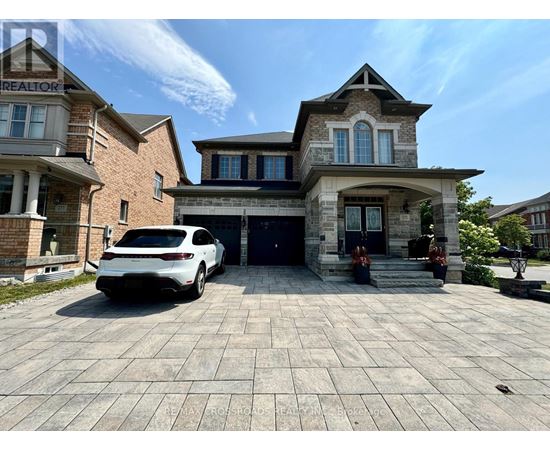 A white car is parked in front of a two-story house.