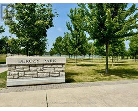 Berczy Park is a beautiful park with a stone sign and trees.