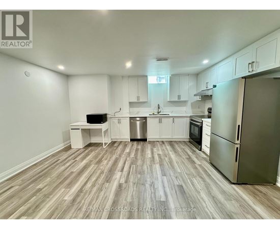 A kitchen with white cabinets and a wooden floor.