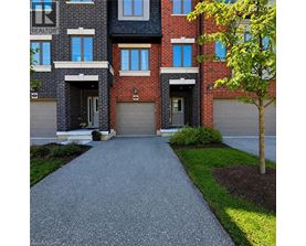 A red brick apartment building with a driveway in front.