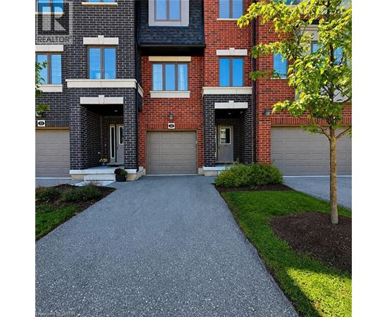 A red brick apartment building with a driveway in front.