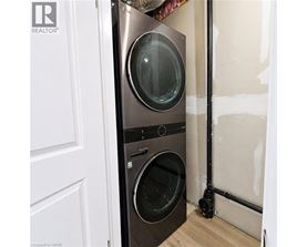 A black front loading washing machine in a room under renovation.