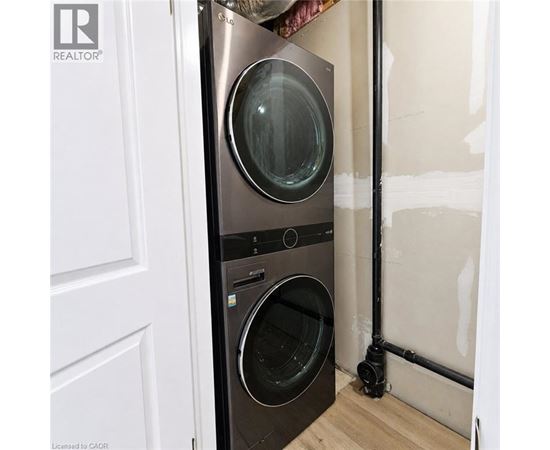 A black front loading washing machine in a room under renovation.