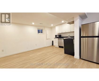 A kitchen with stainless steel appliances and wooden flooring.