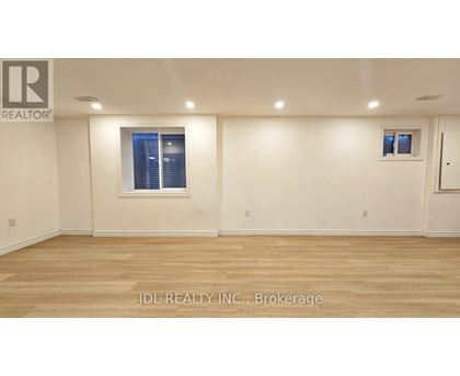 A room with wooden flooring and a window with blinds.