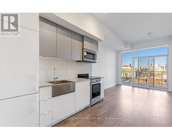 A modern kitchen with white cabinets and a stainless steel sink.