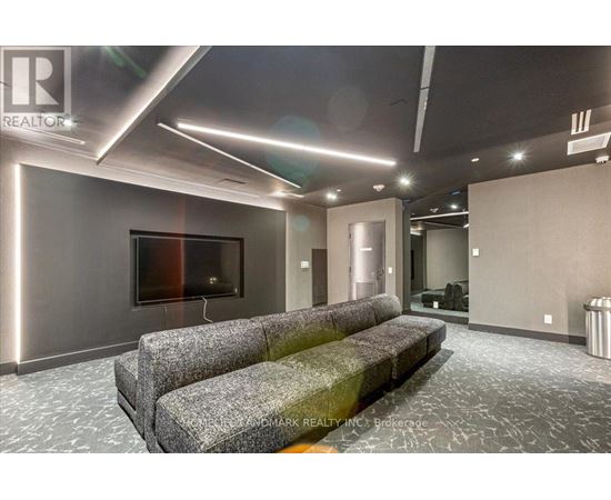 A modern living room with grey couches and a flat screen TV.
