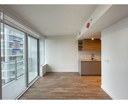 A kitchen area with a sink and a window with a view of a building.