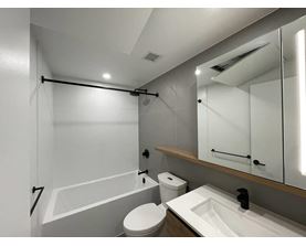 A white bathroom with a toilet, sink, and bathtub.