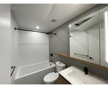 A white bathroom with a toilet, sink, and bathtub.