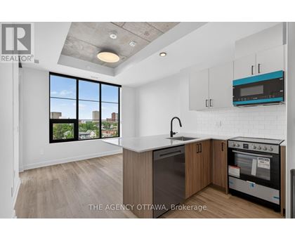 A modern kitchen with a large window overlooking the city.