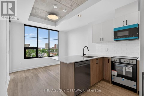A modern kitchen with a large window overlooking the city.