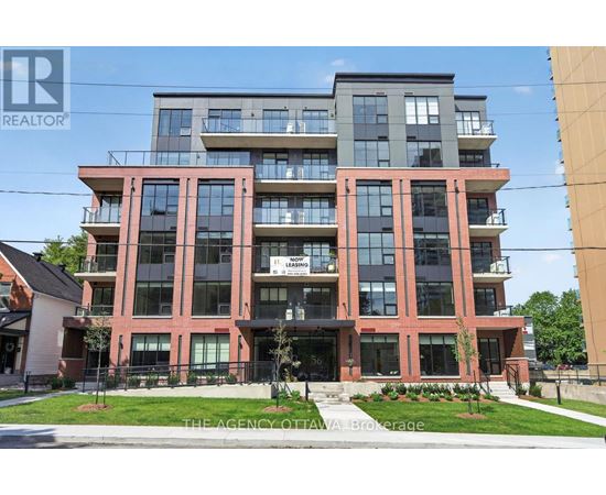 A multi-story building with a realtor sign in front.