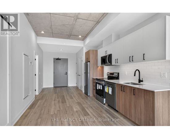 A kitchen with white cabinets and a wooden floor.