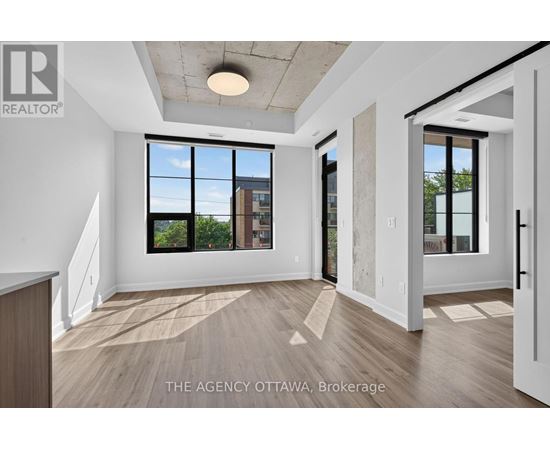 A spacious room with a view of the city through large windows.