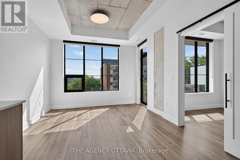 A spacious room with a view of the city through large windows.