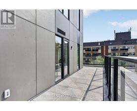 A modern building with a balcony and glass doors.