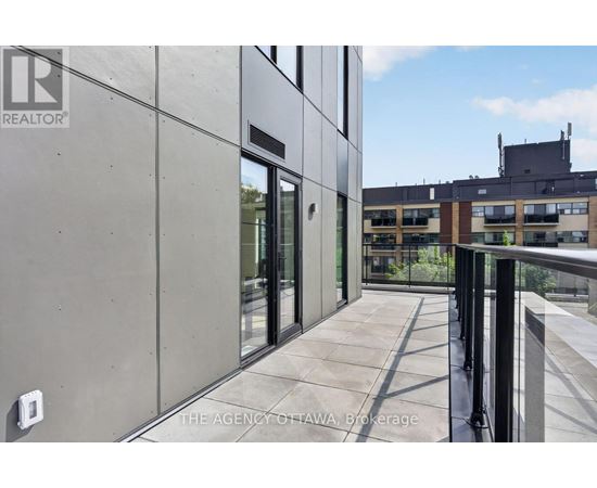 A modern building with a balcony and glass doors.