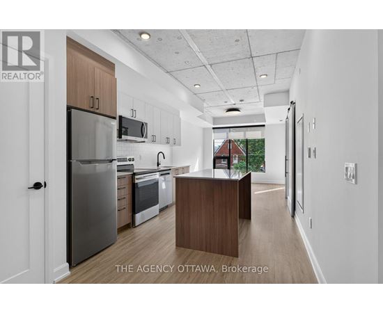 A modern kitchen with a refrigerator, oven, and microwave.