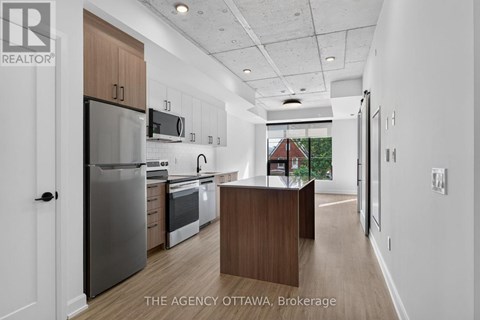 A modern kitchen with a refrigerator, oven, and microwave.