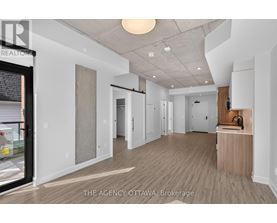 A spacious, empty room with a wooden floor and white walls.