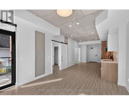 A spacious, empty room with a wooden floor and white walls.