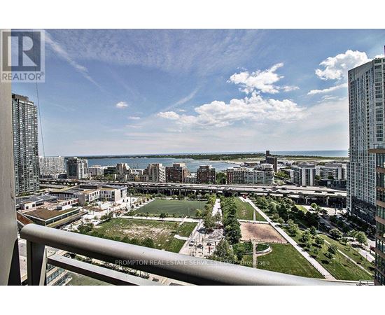 A view from a high-rise building looking down at a cityscape with a large open green space in the foreground.