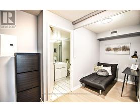 A bedroom with a black bed and a wooden wardrobe.