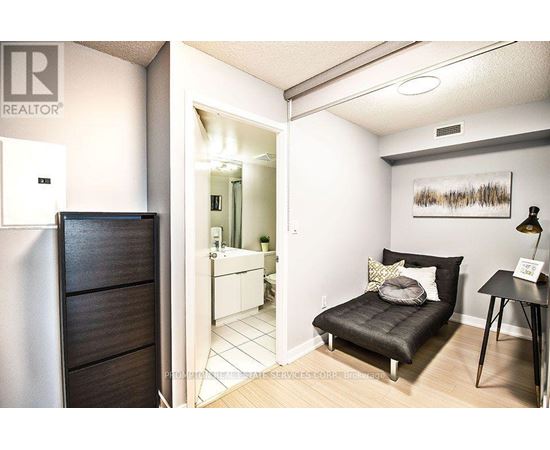 A bedroom with a black bed and a wooden wardrobe.