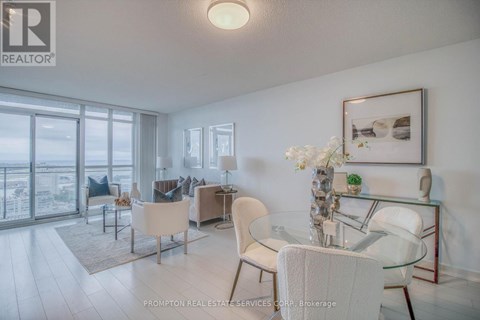 A well-lit, modern living room with a glass table and white chairs.