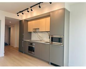 A modern kitchen with stainless steel appliances and wooden cabinets.