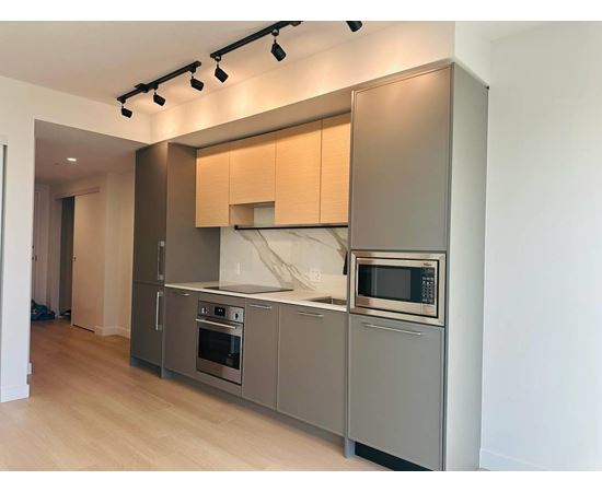 A modern kitchen with stainless steel appliances and wooden cabinets.