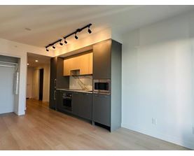 A modern kitchen with wooden floors and stainless steel appliances.