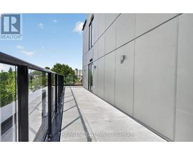 A balcony with a metal railing and a glass door.