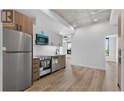 A modern kitchen with a stainless steel refrigerator and wooden cabinets.