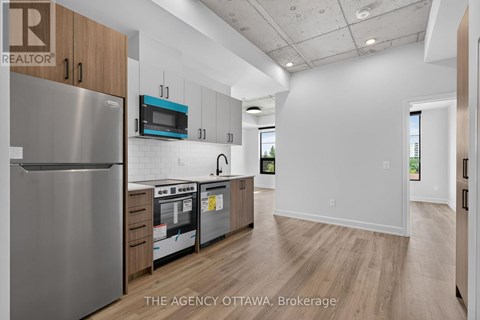 A modern kitchen with a stainless steel refrigerator and wooden cabinets.