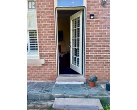 A doorway with a glass window and a sign on the ground.