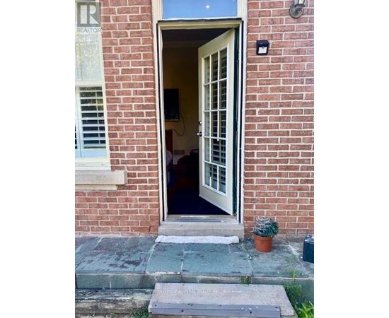 A doorway with a glass window and a sign on the ground.
