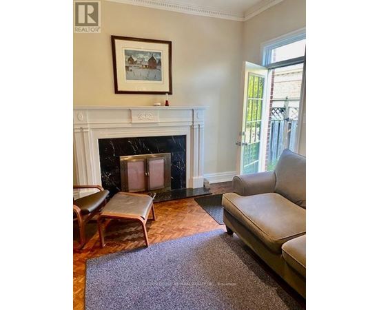 A living room with a fireplace and a painting on the wall.